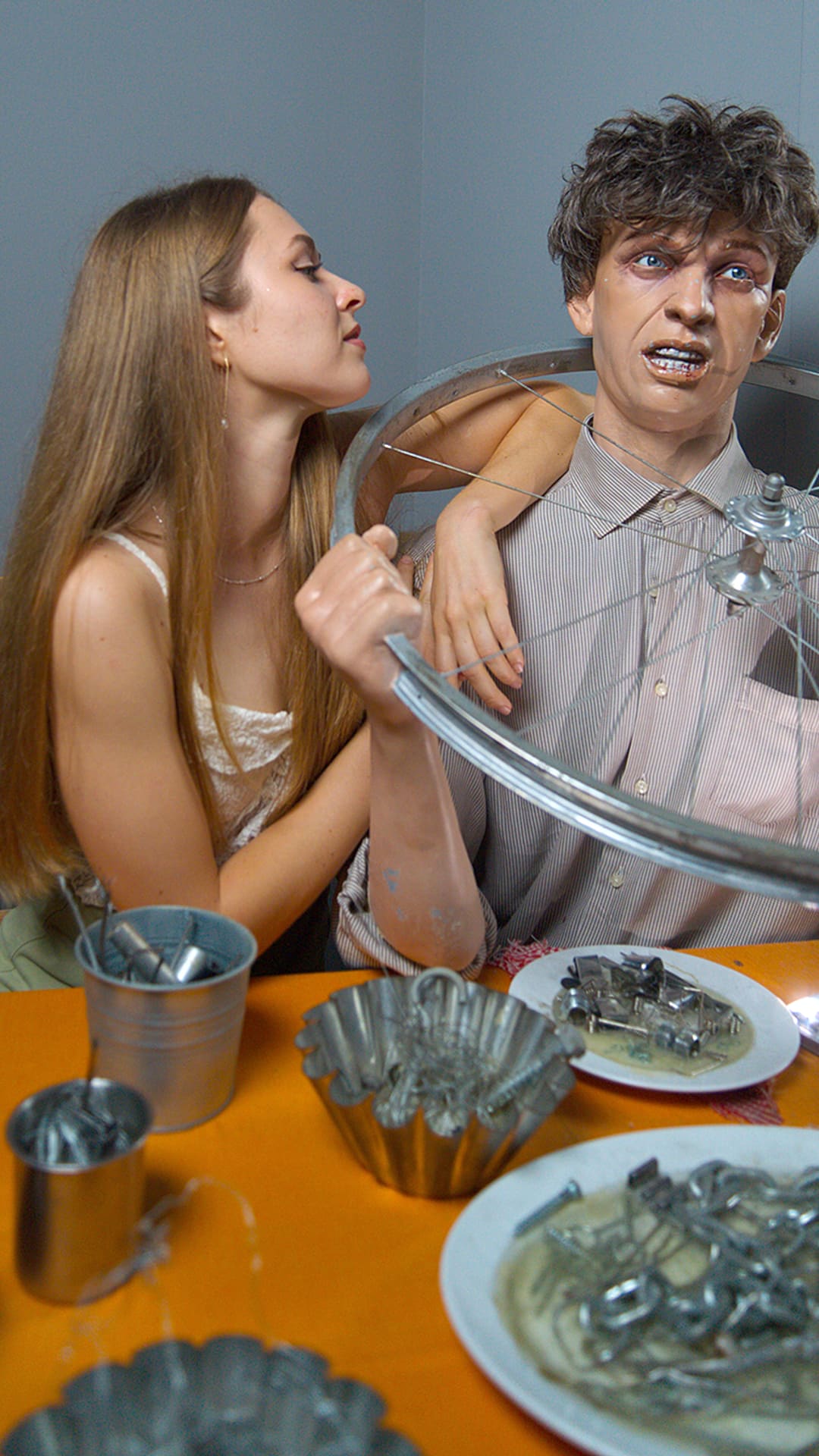 A life-size figure of a man eating a bicycle wheel and metal cutlery at a dinner table at Guinness Records Museum Barcelona